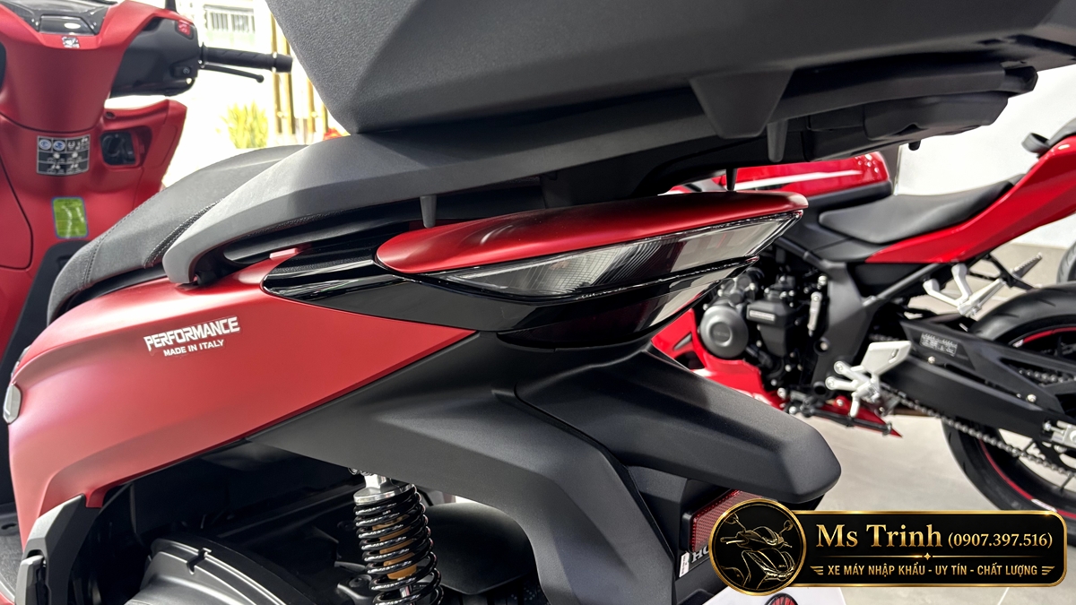 Honda SH350i Sporty màu đỏ nhập Ý nhìn nghiêng bên trái với thùng sau đồng bộ tạo phong cách touring. Honda SH350i Sporty màu đỏ nhập Ý nhìn nghiêng bên trái với thùng sau đồng bộ tạo phong cách touring.